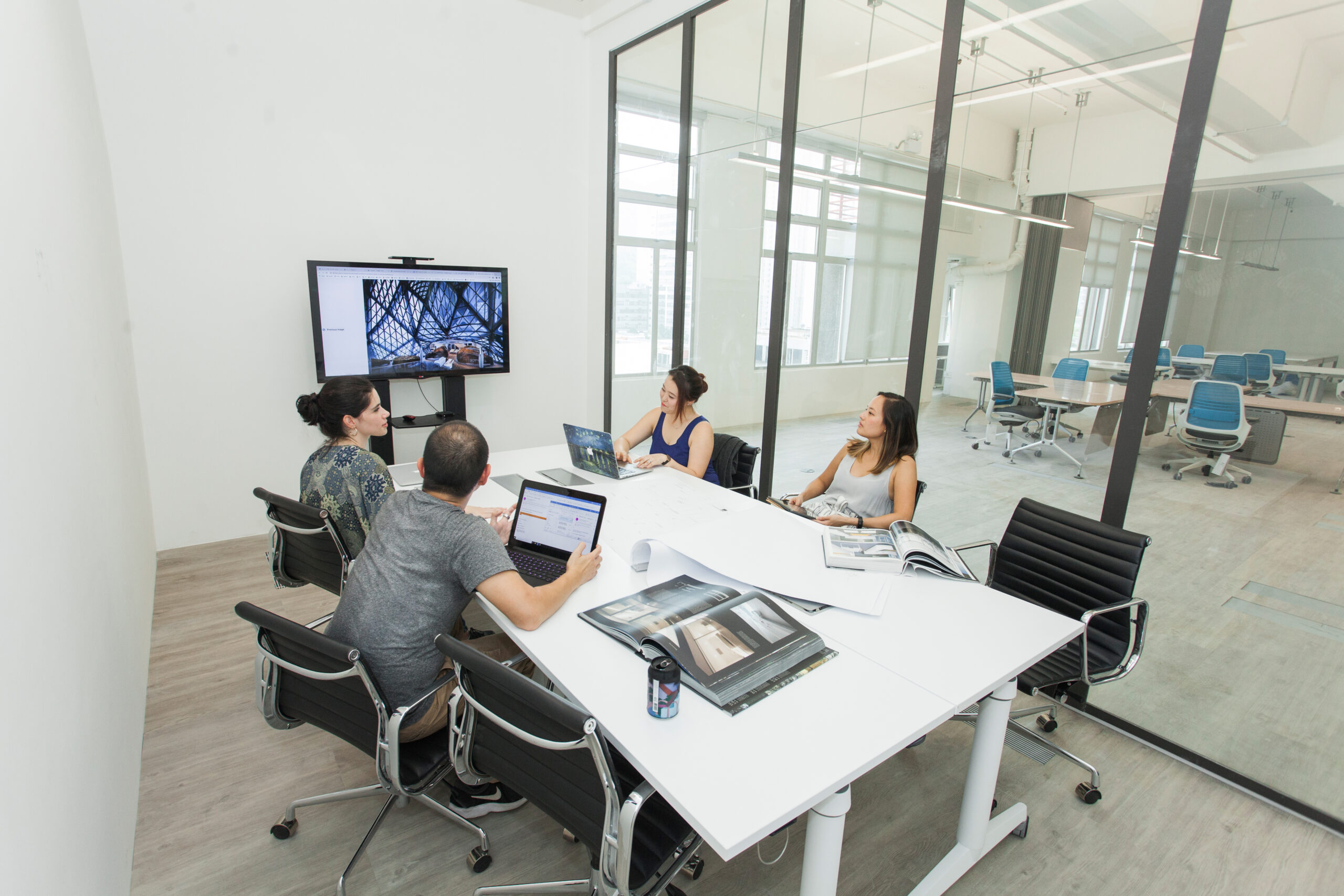 A co-working group sitting around a table in a conference room at an innovative coworking space in Shatin.